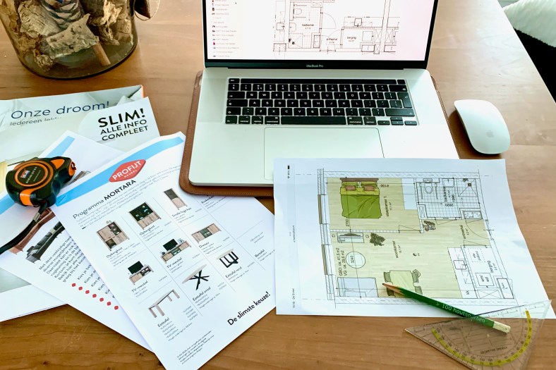 Een laptop en plattegrond van het appartement met meubels ingetekend.